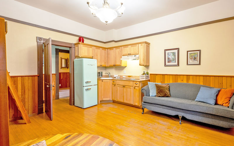Baker-Suite-Living-Space-at-Victoria-Falls-House-Nelson-BC Open-plan living space with a dining table and comfortable seating in the Baker Suite, Victoria Falls House, Nelson BC.